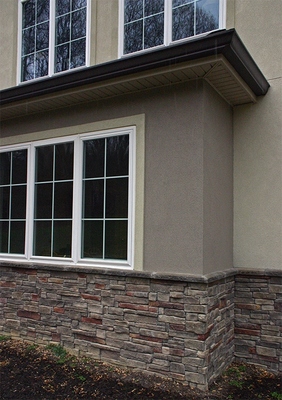 Insulated windows with decorative stone wainscot over Ferrocement structural stucco